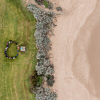 Drone arial shot of 2023 program participants standing in a circle near the shore