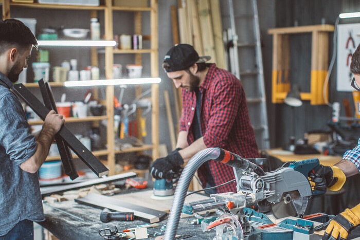 Two men using power tools in small scale manufacturing.