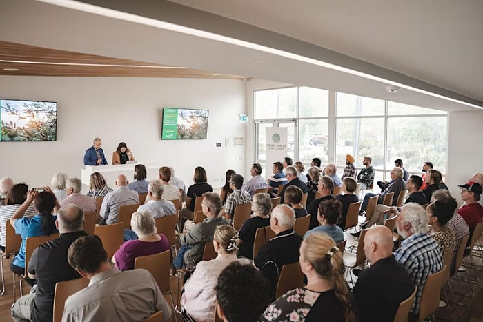 A group of people seated in a large room at Laratinga Pavilion for a workshop.